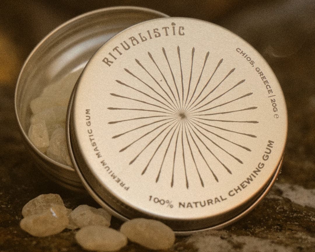 Open Ritualistic tin with mastic tears scattered on warm stone.